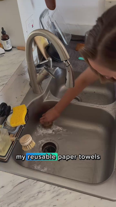 Wiping down a dining table with Reusable Paper Towels in a zero waste cleaning routine