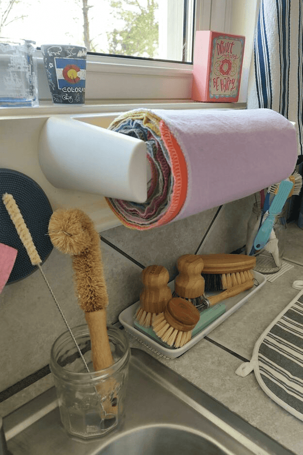 A rainbow roll of Reusable Paper Towels on a wall-mounted holder