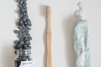 charcoal toothpaste tablets, a bamboo toothbrush, and davids natural toothpaste